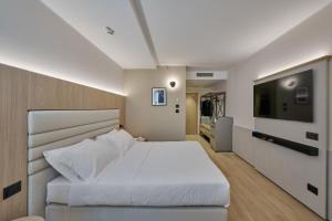 摩德纳RMH Modena Raffaello的卧室配有一张白色大床和一台平面电视。