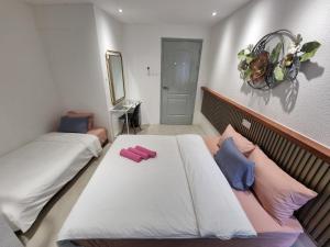 古晋一点酒店的一间卧室配有两张带粉红色和蓝色枕头的床