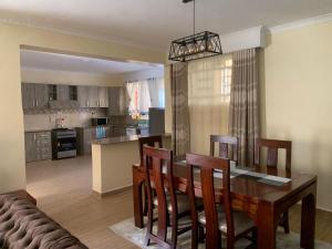 Kitengela Happy home from home的厨房以及带桌椅的用餐室。