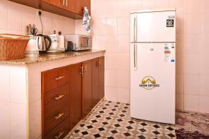 纳库鲁Havan Furnished Apartment-Milimani N9的厨房配有白色冰箱,铺有瓷砖地板。