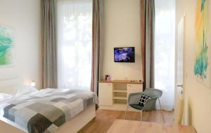 维也纳Riess City Rooms - Self Check-in的卧室配有床、椅子和窗户。