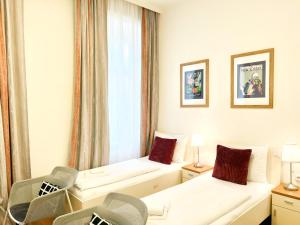 维也纳Riess City Rooms - Self Check-in的酒店客房设有两张床和窗户。