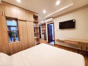 胡志明市Mother's Home的一间卧室配有一张床和一台平面电视