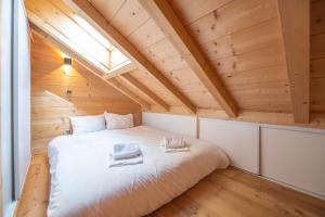 于埃Beau chalet GUSTAVE 4 chambres 50m piste Huez Express的木天花板的客房内的一张床位