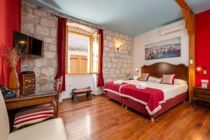 特罗吉尔Heritage Hotel Tragos的一间酒店客房,配有一张床和一台电视