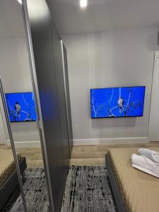 奥尔比亚2 Room Suite Monte Nero- Best price vs quality-Fully equipped & renovated- City Centre的一间卧室设有两张床,墙上配有电视。