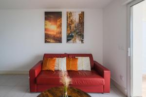 拉卡诺奥肯Appartement - vue exceptionnelle的客厅里一张红色的沙发,配有桌子