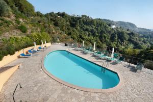 斯培西亚gli ulivi di montalbano 1的一个带椅子和山脉的大型游泳池