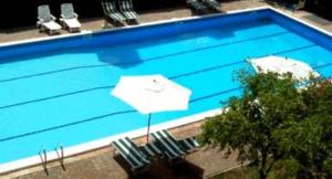 蒙蒂菲阿斯科尼拉康曼达公寓酒店的一个带椅子和遮阳伞的游泳池以及游泳池