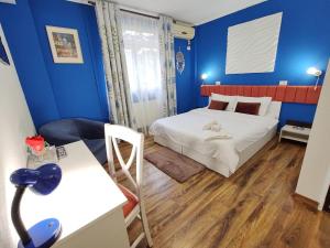 普洛耶什蒂Pensiunea & SPA Boema Ploiesti的小房间设有床和蓝色的墙壁