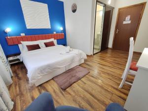 普洛耶什蒂Pensiunea & SPA Boema Ploiesti的一间卧室设有一张大床和蓝色的墙壁
