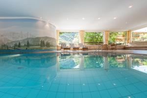科尔皮缇亚Sonnleiten der kleinen Bären 8的设有一个室内游泳池,铺有蓝色的瓷砖地板,配有窗户