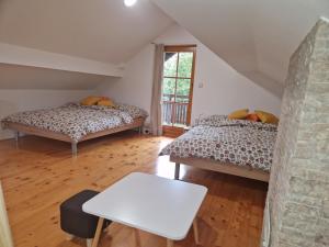 MarkovciSweet Country House的一间设有两张床和一张桌子的房间