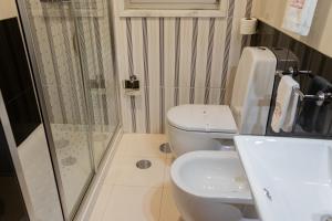 加亚新城Motel Paraíso do Braseiro的带淋浴、卫生间和盥洗盆的浴室