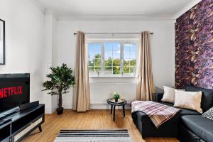 切尔滕纳姆Stunning 4 Bed House - Sleeps 12的带沙发和窗户的客厅