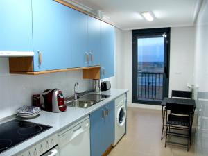 Cirueña高尔夫里奥哈公寓的厨房配有蓝色橱柜、水槽和窗户。