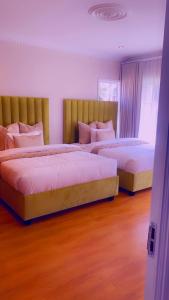 博克斯堡OR Tambo Airport Mansion/self catering/Holiday hme的卧室设有两张床,铺有木地板