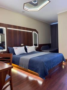 加亚新城Motel Paraíso do Braseiro的一间卧室配有一张大床和木制床头板