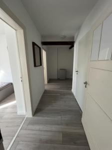 门兴格拉德巴赫MG15 Schönes Maisonette Apartment in schöner Lage的空的走廊,有白色的墙壁和木地板