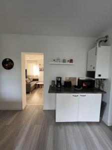门兴格拉德巴赫MG15 Schönes Maisonette Apartment in schöner Lage的一间带白色橱柜的厨房和一间客厅