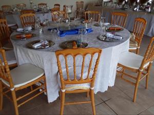 马塞卢Mmelesi Lodge的一张桌子、白色的桌布和木椅
