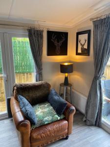 科弗Lovely new caravan by Loch Long的客厅配有真皮座椅和窗户