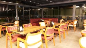伊斯坦布尔Amber Palace Hotel的餐厅设有木桌、椅子和窗户。