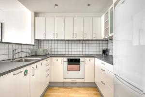 哥本哈根Amazing Two Bedroom Flat in Urban Area的白色的厨房配有白色橱柜和水槽