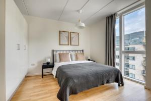 哥本哈根Amazing Two Bedroom Flat in Urban Area的一间卧室设有一张床和一个大窗户