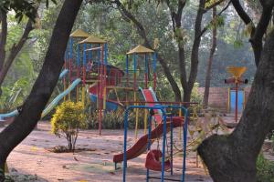 VasindSrushti Farms Resort的树木繁茂的公园里一个带滑梯的游乐场