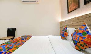 孟买FabExpress The DR Residency的一间卧室配有一张大床和色彩缤纷的被子