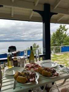 Exclusive panorama view of the Oslofjord的一张桌子,上面放着食物和葡萄酒