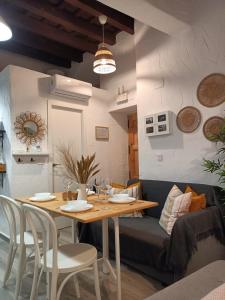 赫雷斯-德拉弗龙特拉Loft Xera - parking privado的一间带桌子和沙发的用餐室