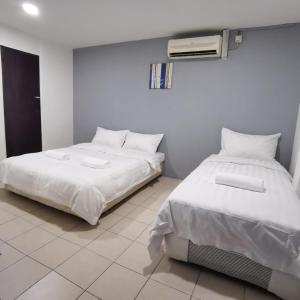拉布安Hotel Seroja的两张睡床彼此相邻,位于一个房间里