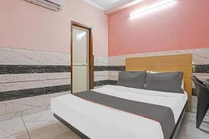 新德里Flagship Prithvi Residency的卧室配有1张床、1张桌子和1把椅子