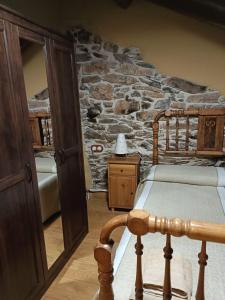 Lago de CarucedoCasa do Eiró的一间卧室设有石墙、一张床和一张桌子