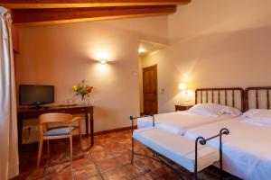 阿坝洛斯阿巴洛斯别墅酒店的一间卧室配有两张床、一张桌子和一台电视。