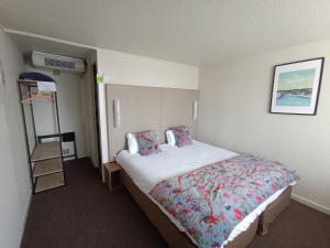 坎佩尔Brit Hotel Quimper Sud的一间酒店客房,房内配有一张大床