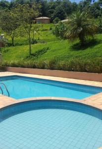 南蒙蒂阿莱格里Recanto dos Beija Flores, Chalé lantana e的享有田野景致的大型蓝色游泳池