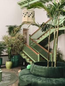 阿索马达Hotel Cesar Lanzarote的客厅设有楼梯和绿色沙发