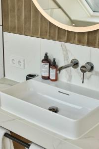 韦斯特兰DAS LORNSEN - Serviced Luxury Apartments的浴室设有白色水槽和镜子