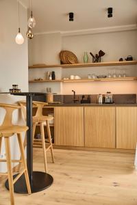 韦斯特兰DAS LORNSEN - Serviced Luxury Apartments的厨房配有木制橱柜和带凳子的台面