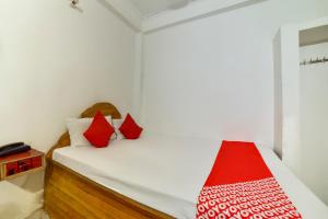 HājīpurOYO Flagship Mamta Hotel的小卧室配有红色枕头的床