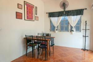 清迈Baan Ragang : Cozy Entire House in Old Chiang Mai的一间带桌椅和窗户的用餐室