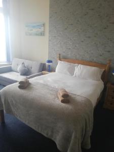 布莱克浦Camelot Seafront Hotel的一间卧室配有一张床,上面有两条毛巾