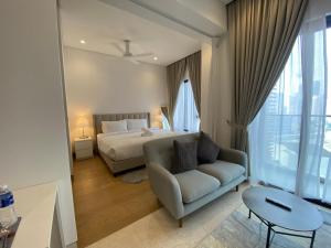 吉隆坡Lalaport Suites At Lucentia Bukit Bintang City Center的一间卧室配有一张床、一张沙发和一张桌子