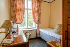 派尔努维多利亚酒店的客房设有床、书桌和窗户。