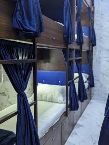 孟买Ayala PG Dormitory的一间客房内的两张双层床和蓝色窗帘