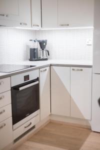 罗瓦涅米Apartment Malla的厨房配有白色橱柜和炉灶烤箱。