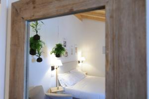 蒙特堡Montegusto的卧室配有一张床,墙上挂有两株植物